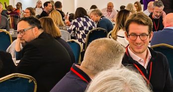 a close up of people chatting in a conference setting